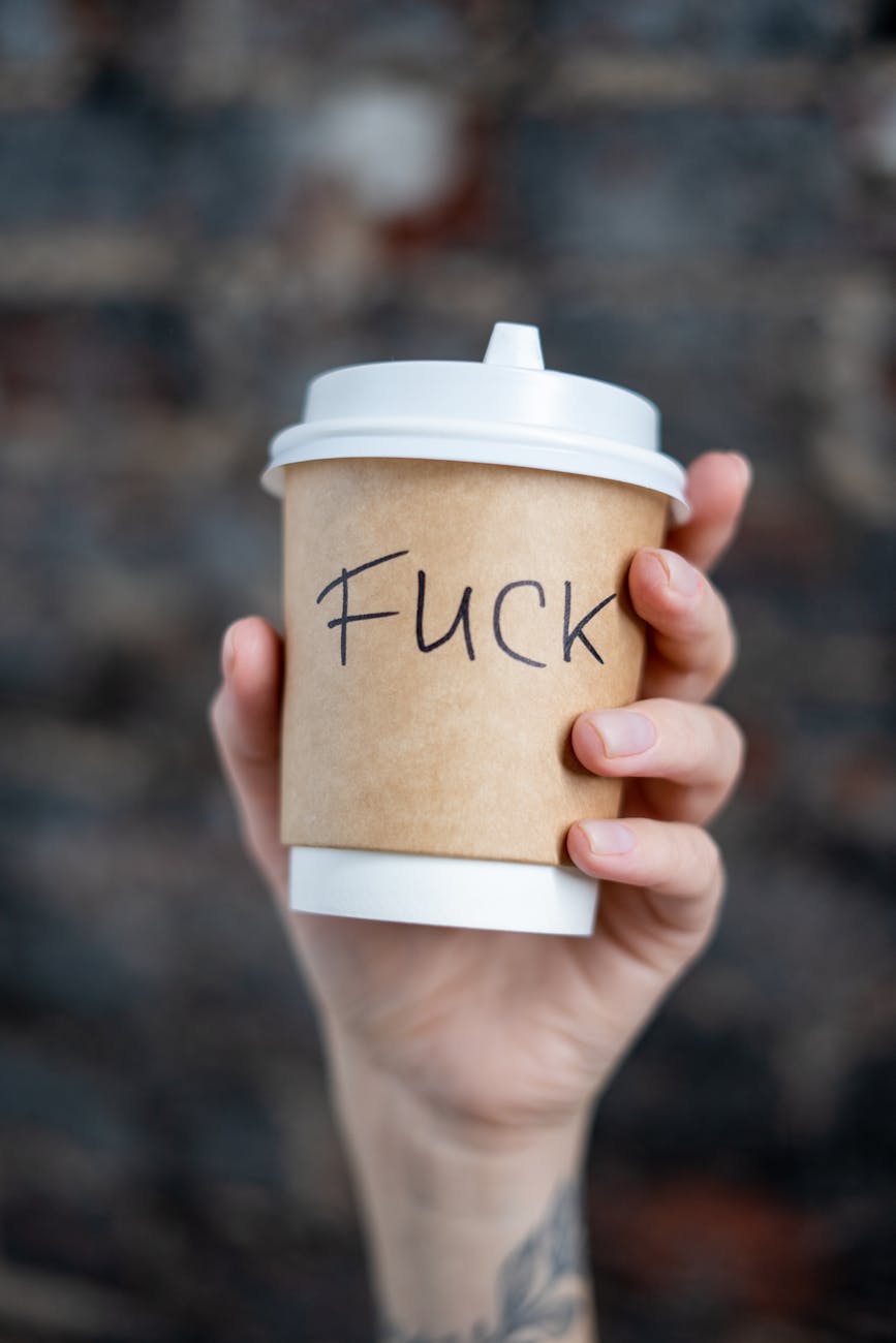 close up shot of a person holding a disposable cup